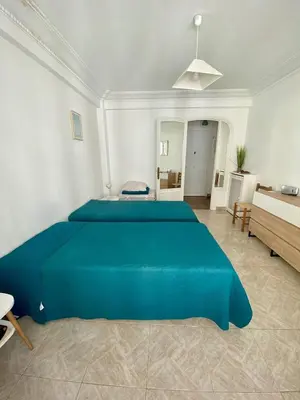 a large blue bed in a white room with a bathroom at Cannes proche Croisette - 2 pièces lumineux in Cannes