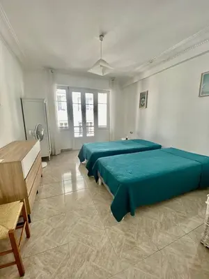 a room with three beds with green sheets at Cannes proche Croisette - 2 pièces lumineux in Cannes