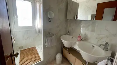 a white bathroom with a sink and a mirror at Chez Marilyne & Jean Baptise in Cannes