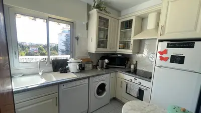 a kitchen with white cabinets and a sink and a dishwasher at Chez Marilyne & Jean Baptise in Cannes
