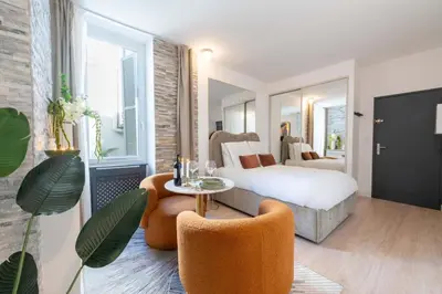 a hotel room with a bed and a table and chairs at Studio design au centre de Cannes proche Croisette climatisé in Cannes