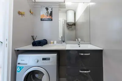 a small kitchen with a washing machine and a sink at Studio design au centre de Cannes proche Croisette climatisé in Cannes