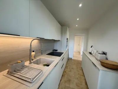 a kitchen with white cabinets and a sink at Spacious 2-bedroom sea view with parking in Palm Beach in Cannes