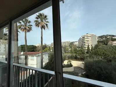 a view of palm trees from a balcony at Spacious 2-bedroom sea view with parking in Palm Beach in Cannes
