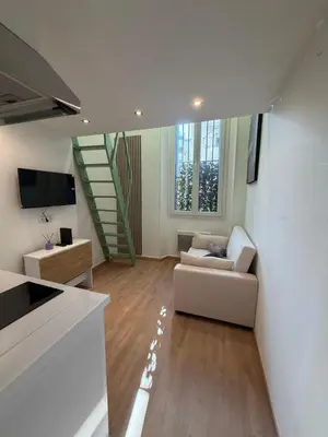 a living room with a couch and a staircase at Studio Moderne à 10 min à pied Palais & Plages in Cannes
