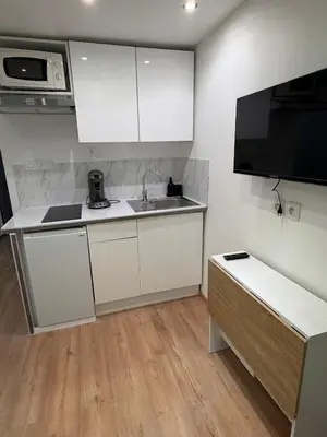 a kitchen with white cabinets and a sink and a microwave at Studio Moderne à 10 min à pied Palais & Plages in Cannes