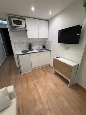 a small kitchen with white cabinets and a microwave at Studio Moderne à 10 min à pied Palais & Plages in Cannes