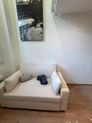a couch with two pillows on it in a room at Studio Moderne à 10 min à pied Palais & Plages in Cannes