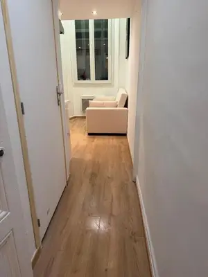 a hallway with a living room with a couch at Studio Moderne à 10 min à pied Palais & Plages in Cannes