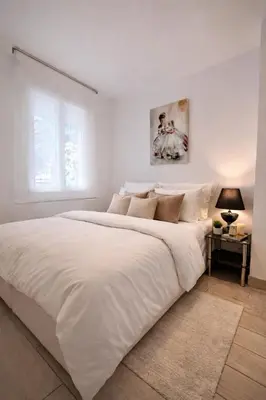 a white bedroom with a large bed and a window at Luxury Cannes Suite Terrace Walk to Palais in Cannes