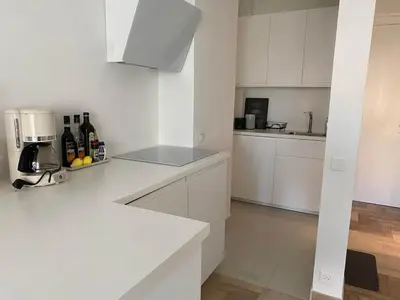 a white kitchen with white cabinets and a counter top at Coastal Retreat Studios with Balcony in Cannes
