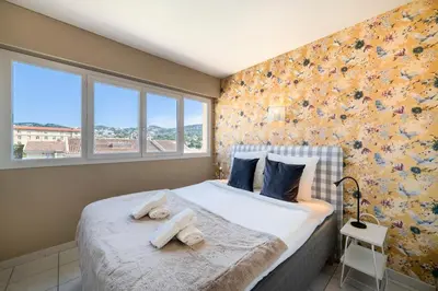 a bedroom with a large bed with towels on it at Two bed - Walk to the beach in Cannes