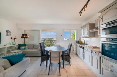 a kitchen and living room with a table and a couch at Two bed - Walk to the beach in Cannes