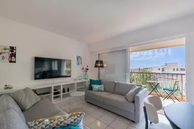a living room with a couch and a television at Two bed - Walk to the beach in Cannes