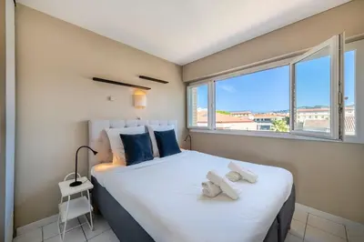 a bedroom with a large bed with towels on it at Two bed - Walk to the beach in Cannes