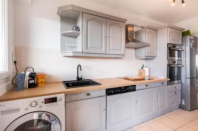 a kitchen with white cabinets and a dishwasher at Two bed - Walk to the beach in Cannes