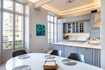 a kitchen with a white table and chairs and windows at Luxury apartment in Cannes in Cannes