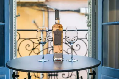 a bottle of wine on a table with two glasses at Charming 1-Bedroom Townhouse in Cannes