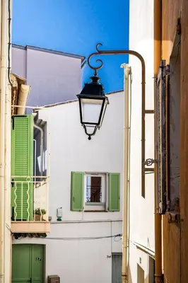 an alley with green doors and a street light at Charming 1-Bedroom Townhouse in Cannes