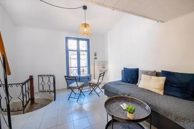 a living room with a couch and a table at Charming 1-Bedroom Townhouse in Cannes