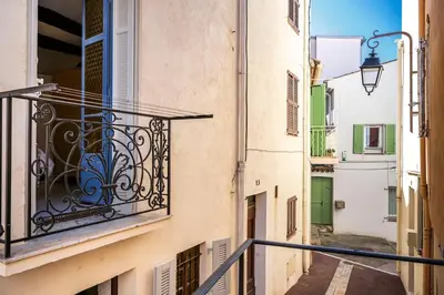 an alley with a balcony on a building at Charming 1-Bedroom Townhouse in Cannes