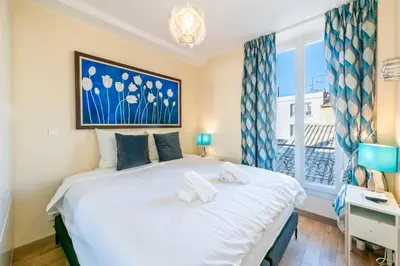 a bedroom with a large white bed with a window at Two Bedrooms - 250m to the beach in Cannes