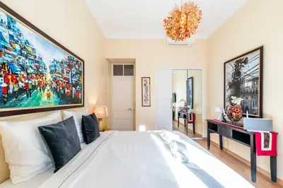 a bedroom with a white bed with a large painting on the wall at Private Garden 3-Bed in Cannes in Cannes