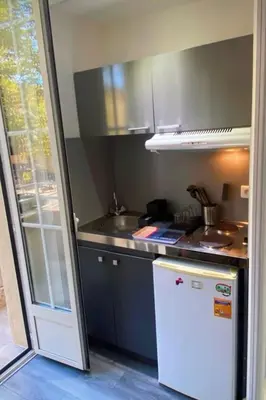 a small kitchen with a white refrigerator and a sink at Smart 2 Apart - Le 62 Cannes in Cannes