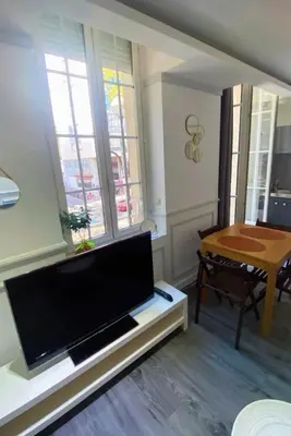 a living room with a flat screen tv and a table at Smart 2 Apart - Le 62 Cannes in Cannes
