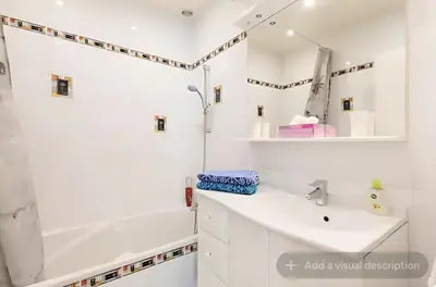 a white bathroom with a tub and a sink at Croisette Top Floor 2BR with Bay View Balcony in Cannes