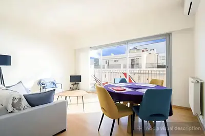 a living room with a dining room table and chairs at Croisette Top Floor 2BR with Bay View Balcony in Cannes