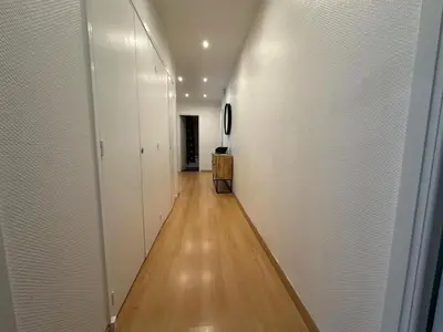 a hallway with white walls and a wooden floor at Croisette Top Floor 2BR with Bay View Balcony in Cannes