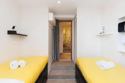 two beds in a room with yellow beds at Palais Prestige YourHostHelper in Cannes