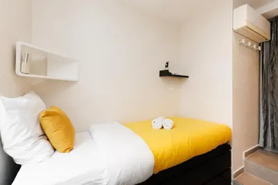 a bedroom with a bed with two clocks on it at Palais Prestige YourHostHelper in Cannes