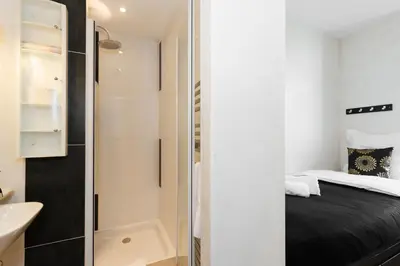 a small bathroom with a bed and a shower at Palais Prestige YourHostHelper in Cannes