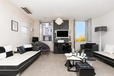 a living room with a couch and a tv at Palais Prestige YourHostHelper in Cannes