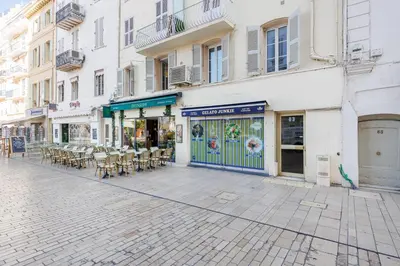 an empty street with a restaurant with tables and chairs at Palais Prestige YourHostHelper in Cannes