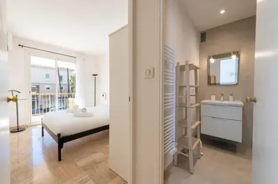 a bedroom with a bed and a bathroom with a sink at 2-Br Apartment with Terrace Near Cannes Centre in Cannes