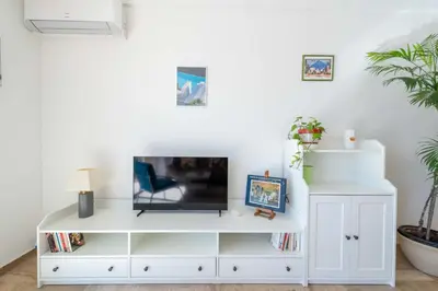 a living room with a tv on a white entertainment center at 2-Br Apartment with Terrace Near Cannes Centre in Cannes