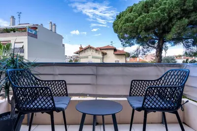 three chairs and a table on a balcony at L'HARMONIE DE CARNOT avec Balcon in Cannes