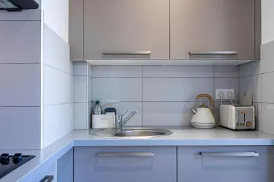 a kitchen counter with a sink and appliances in it at L'HARMONIE DE CARNOT avec Balcon in Cannes