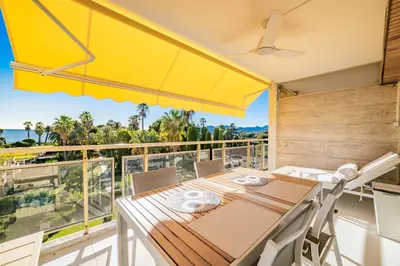 a dining room with a table and chairs on a balcony at KEM15 Appartement avec vue mer in Cannes
