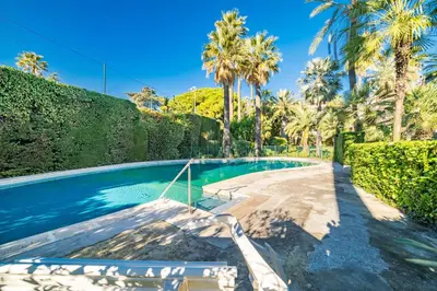 a swimming pool with trees and palm trees at KEM15 Appartement avec vue mer in Cannes