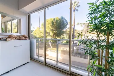 a living room with a large window and plants at KEM15 Appartement avec vue mer in Cannes