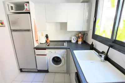 a small kitchen with a washing machine and a sink at air-conditionned apartment 2 bedrooms & bathrooms with refined decoration in Cannes