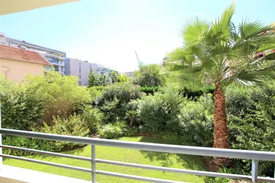 a view of a palm tree from a balcony at air-conditionned apartment 2 bedrooms & bathrooms with refined decoration in Cannes
