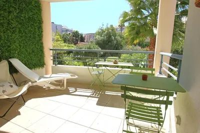 a patio with a table and chairs on a balcony at air-conditionned apartment 2 bedrooms & bathrooms with refined decoration in Cannes