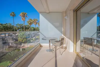 a room with a balcony with a table and chairs at REF 2052 - Seasonal rental - Prestigious apartment on the Croisette Cannes in Cannes