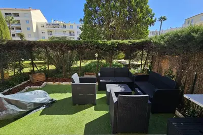 a garden with a couch and chairs on the grass at Bright studio apartment with terrace in Cannes in Cannes