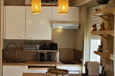 a kitchen with white cabinets and a sink at Bright studio apartment with terrace in Cannes in Cannes